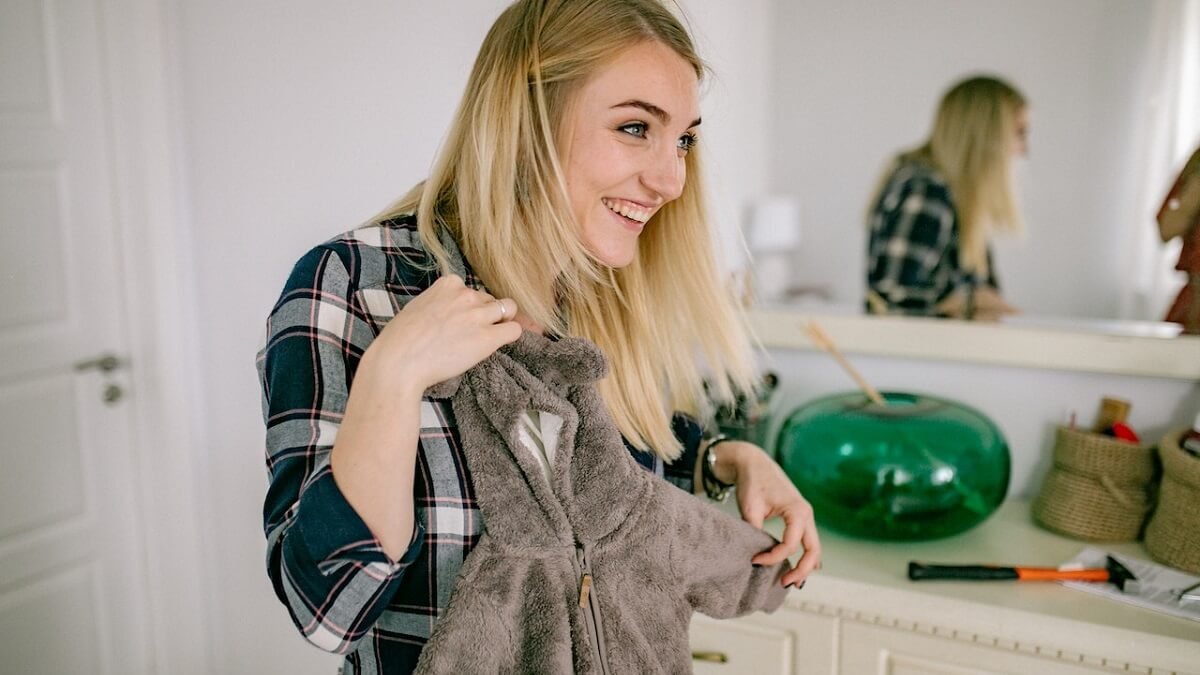 Mulher com uma roupa de criança na mão